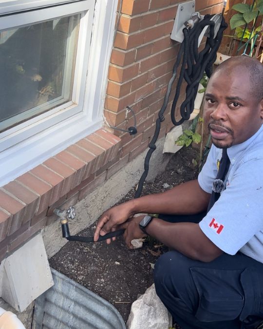 Plumber inspecting an outdoor hose bib