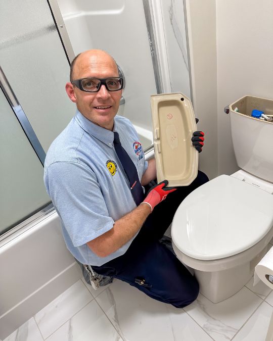 Plumber repairing a running toilet